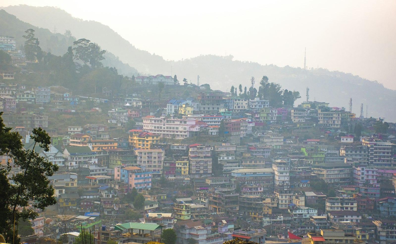 Houses packed across a hillside in Kohima under morning fog